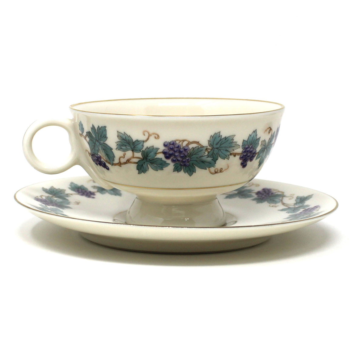 View of single cup and saucer, vintage set from Theodore Haviland, in the Arbor pattern with grape clusters and leaves.