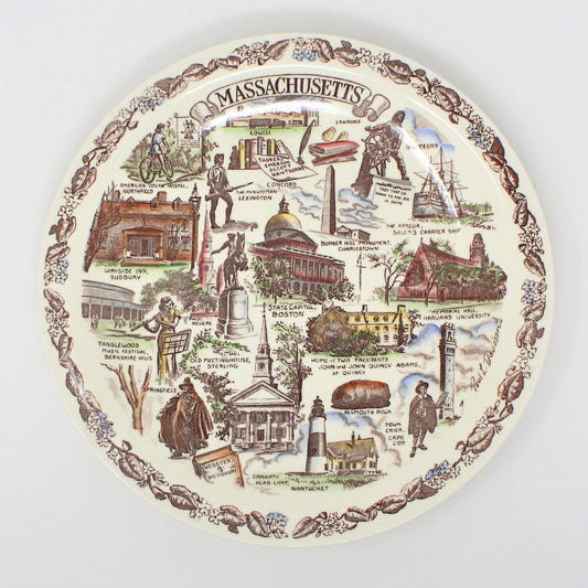 A decorative ceramic plate with a vintage brown transferware design featuring various landmarks and scenes related to the state of Massachusetts, including the Boston State Capitol and Plymouth Rock.