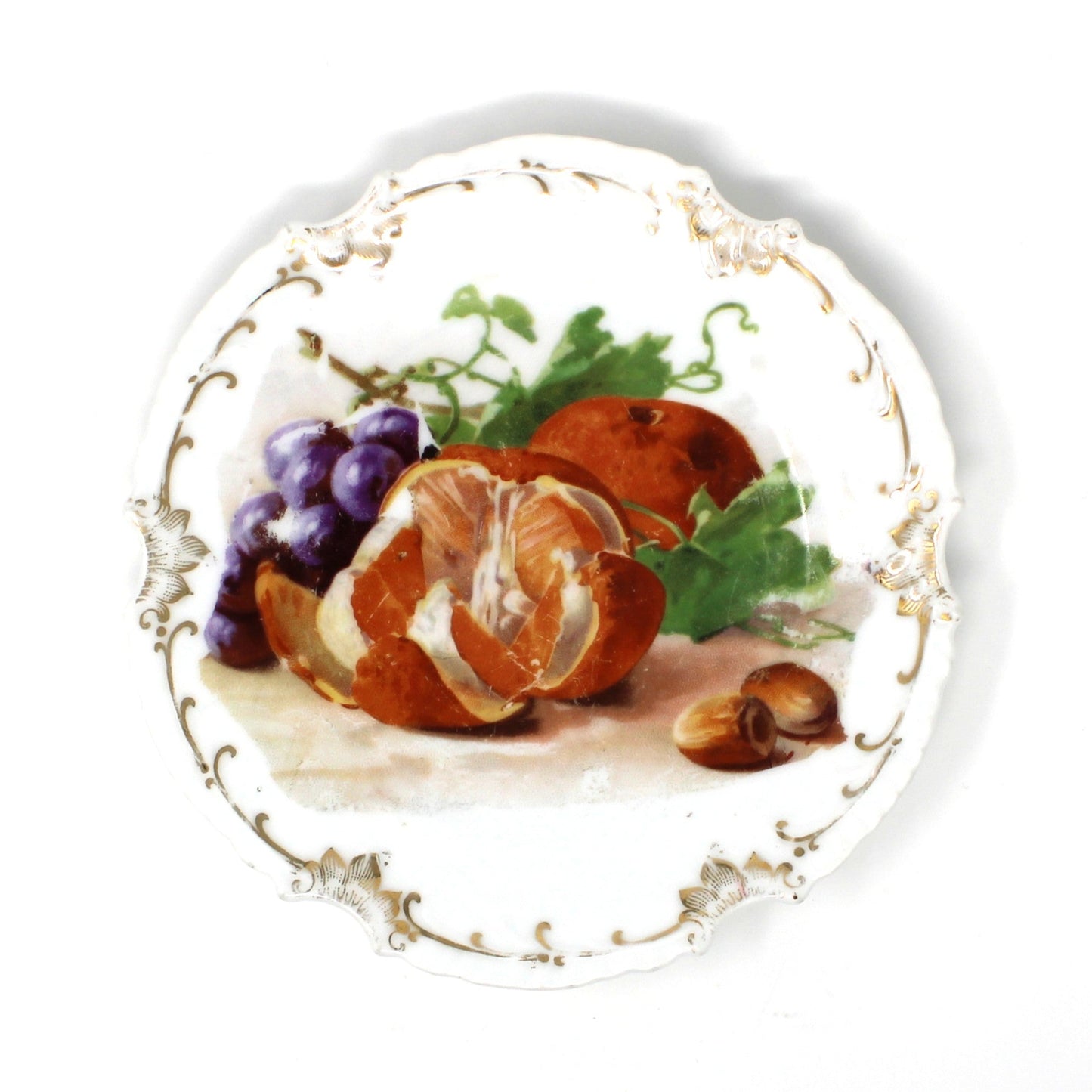 Decorative antique plate with fruits and nuts on a white background with gold accents