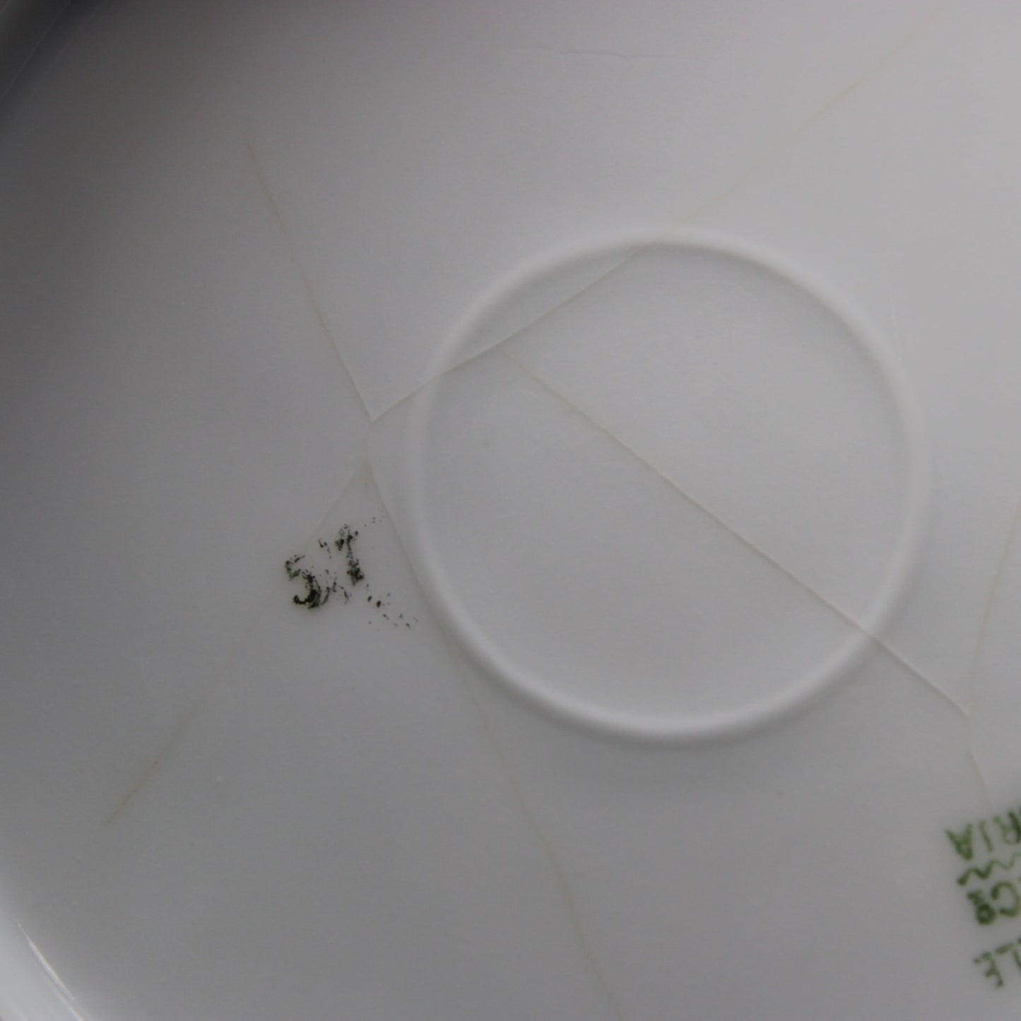 Close-up of a white antique porcelain  plate with crazing on the backside.