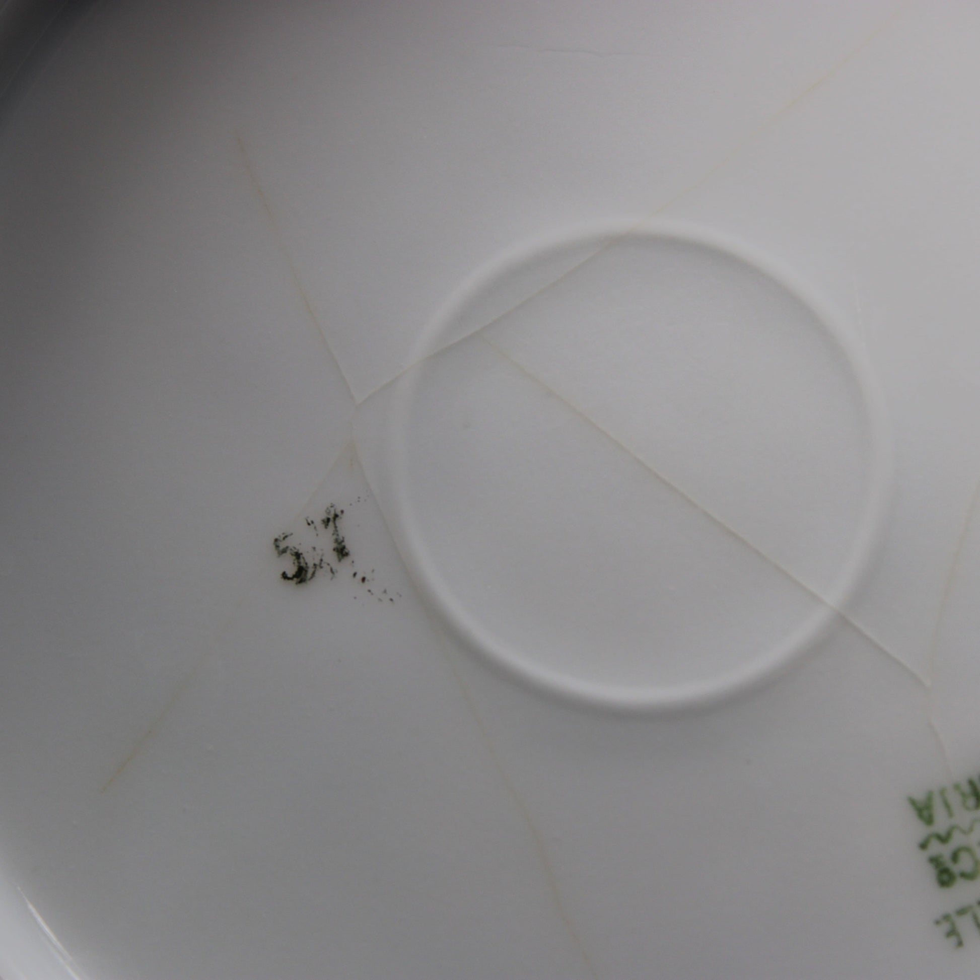 Close-up of a white antique porcelain  plate with crazing on the backside.