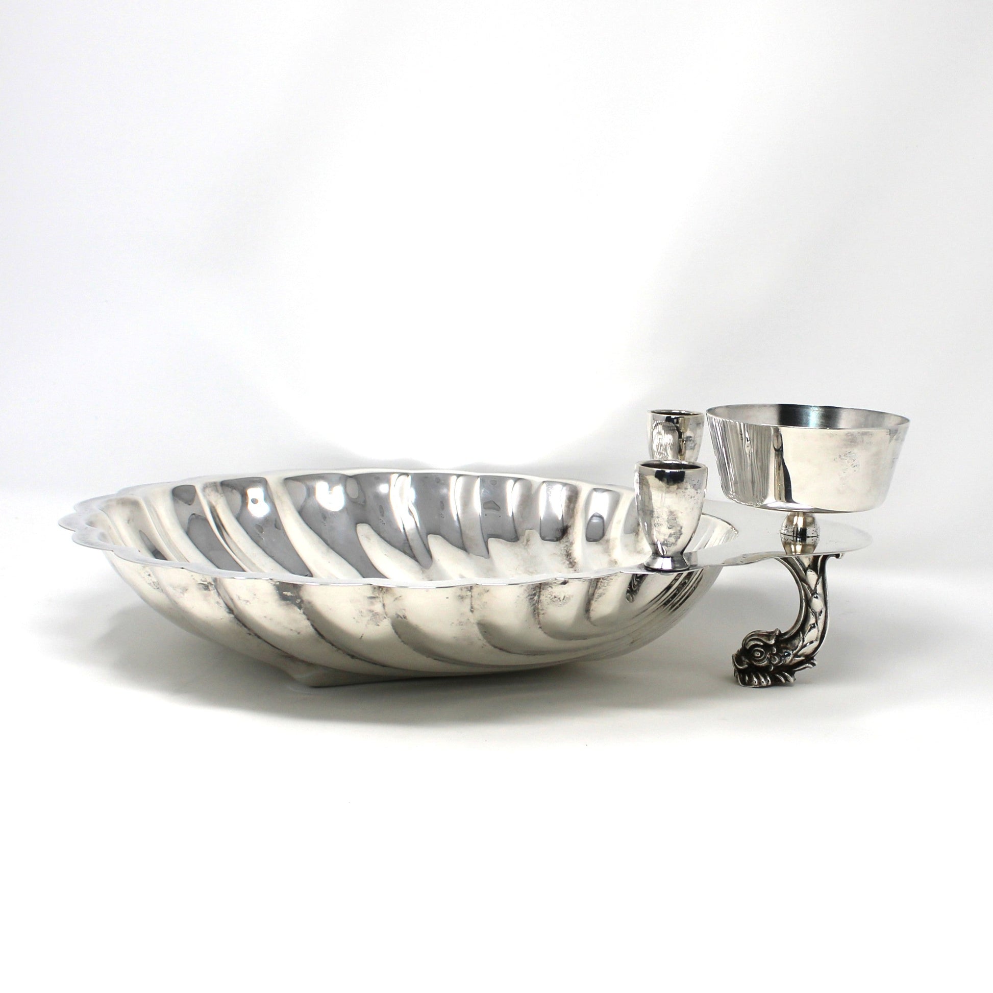 Silver clam shell shaped bowl with a dolphin shaped foot