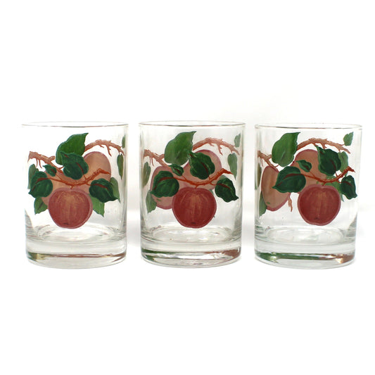 Three glass tumblers with fruit design on a white background