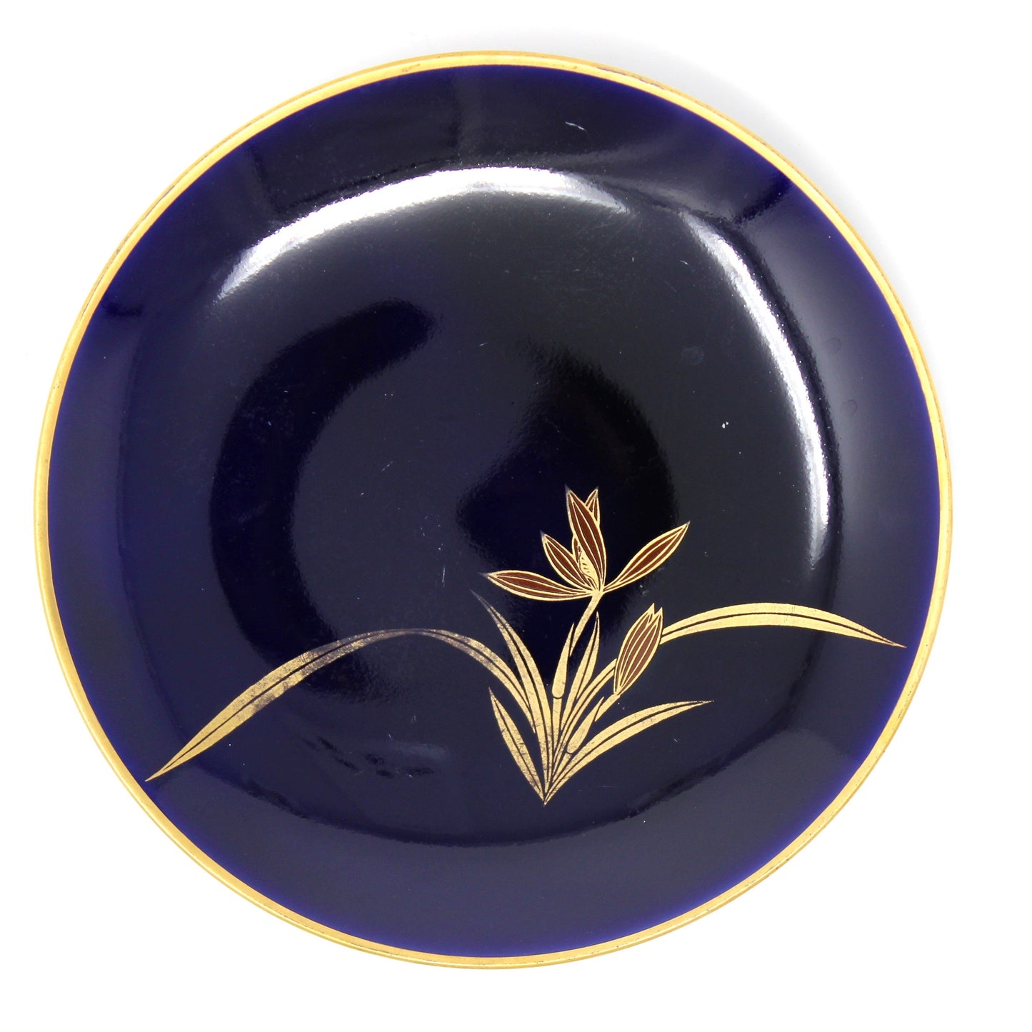 Navy blue plate with gold floral design on a white background
