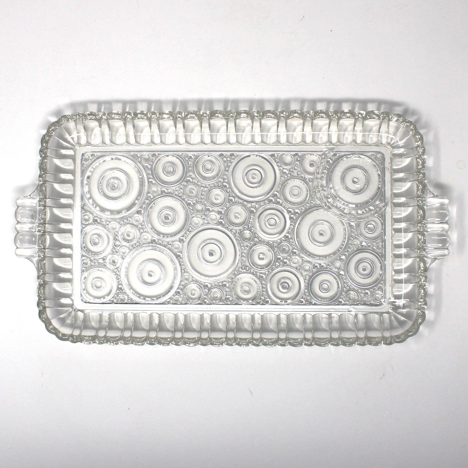 Clear glass snack tray from Anchor Hocking Serva Snack set.  Geometric circles pattern called Colonial Lady.