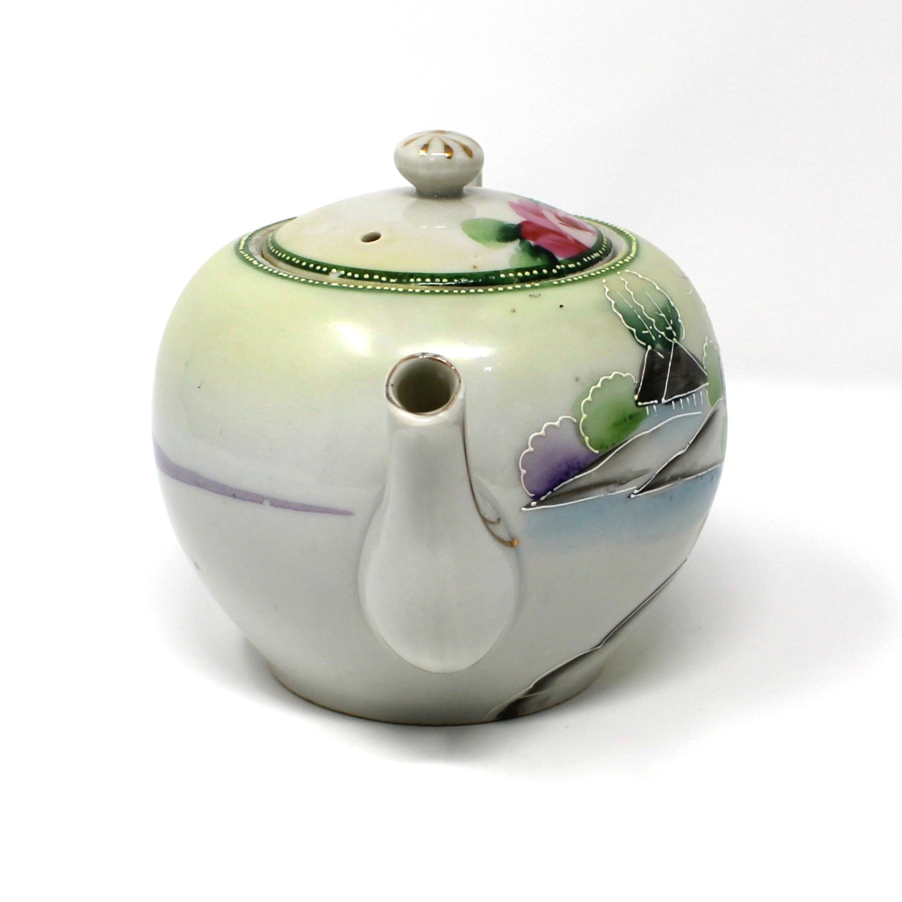 Ceramic teapot with floral design on a white background