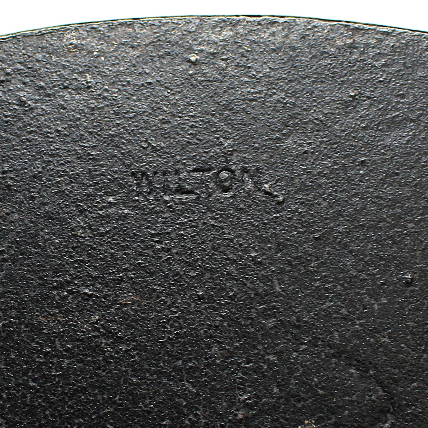 Close-up of a black cast iron bookend with 'Wilton' branding 
