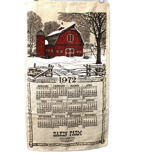 Tea towel with a red barn and vintage-style calendar design on a white background