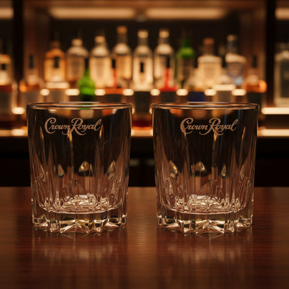 Two cut crystal whiskey glasses with branding for Crown Royal.