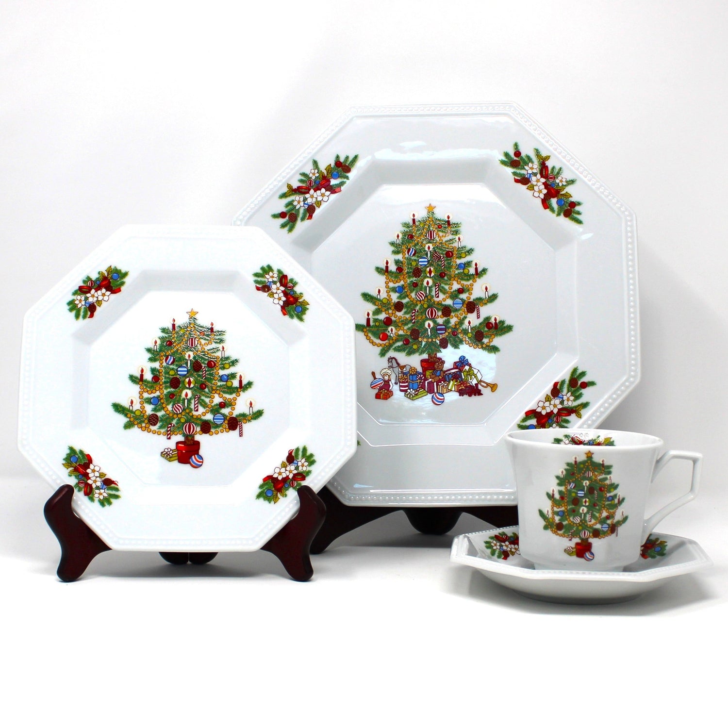 Vintage Christmas-themed dinnerware set with tree and gift designs. complete set for four people.