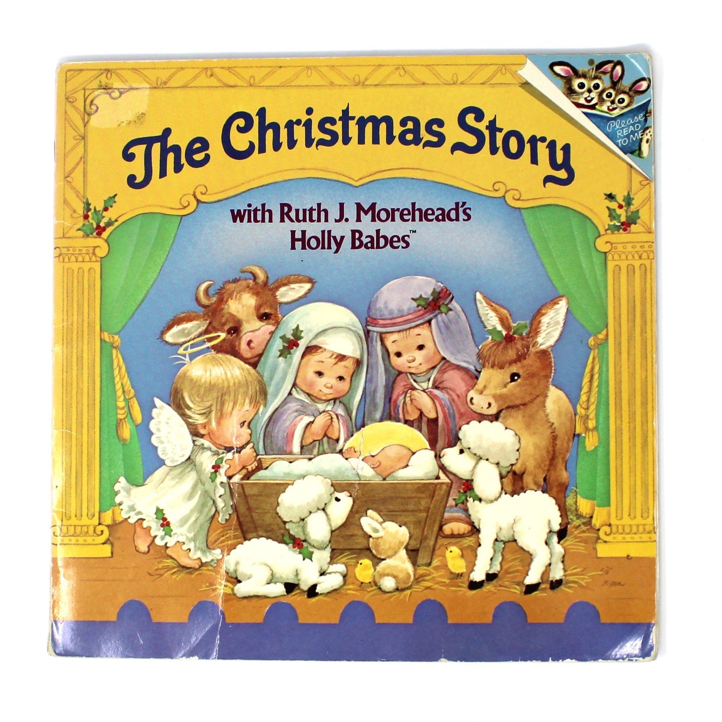 Children's book titled 'The Christmas Story' on a white surface with a decorative item in the corner.
