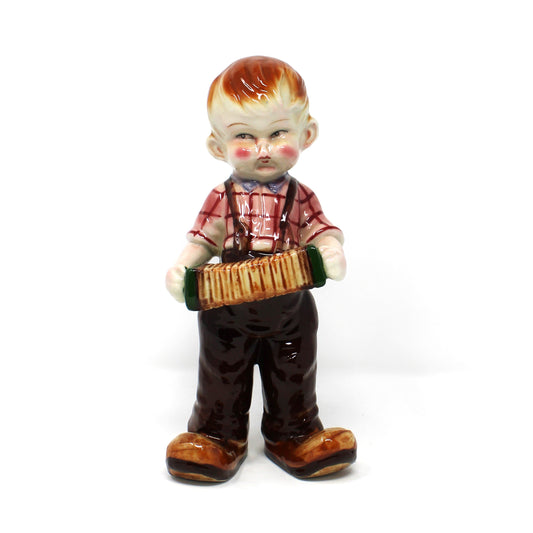 Vintage large Mid Century figurine of a boy playing the accordion, wearing overalls and a striped shirt.