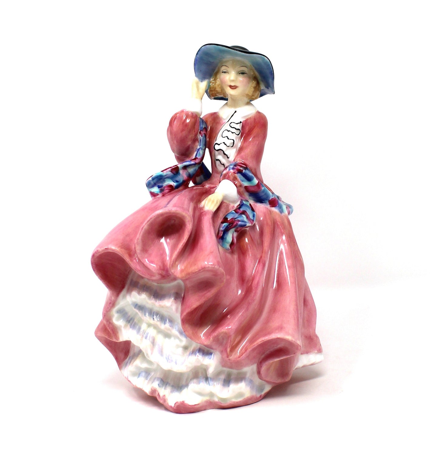 A vintage porcelain Royal Doulton figurine titled "Top O' The Hill". HN1849, of a woman in a flowing pink dress with blue hat.