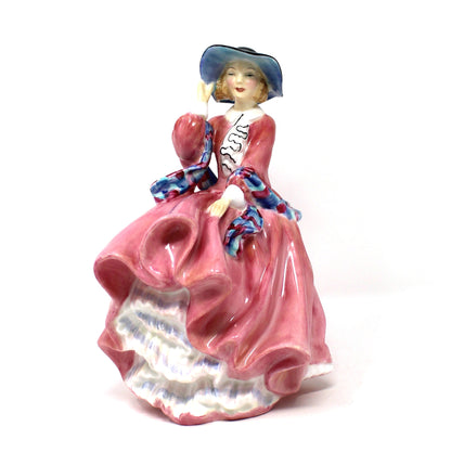 A vintage porcelain Royal Doulton figurine titled "Top O' The Hill". HN1849, of a woman in a flowing pink dress with blue hat.
