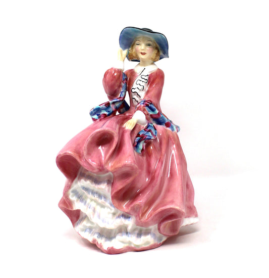 A vintage porcelain Royal Doulton figurine titled "Top O' The Hill". HN1849, of a woman in a flowing pink dress with blue hat.