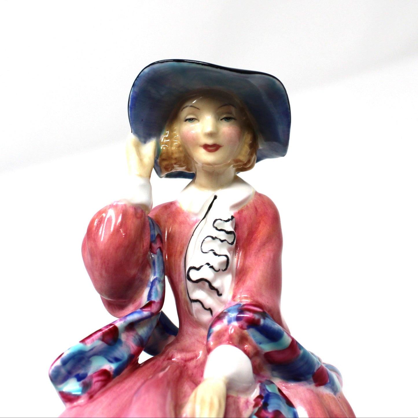 Close up of lady's face on a vintage porcelain Royal Doulton figurine titled "Top O' The Hill". 