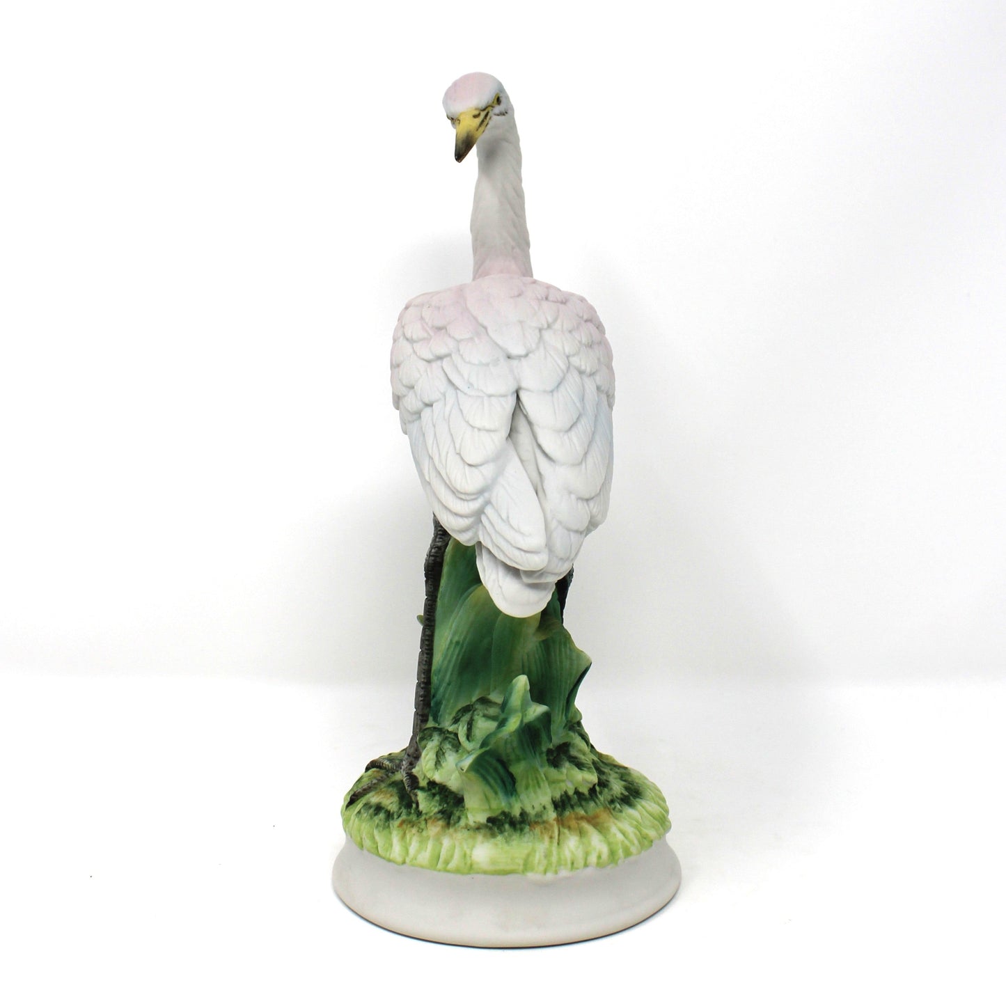Side view of A vintage ceramic bird figurine depicting a white heron standing on a green textured base.  Angeline Originals, Japan.