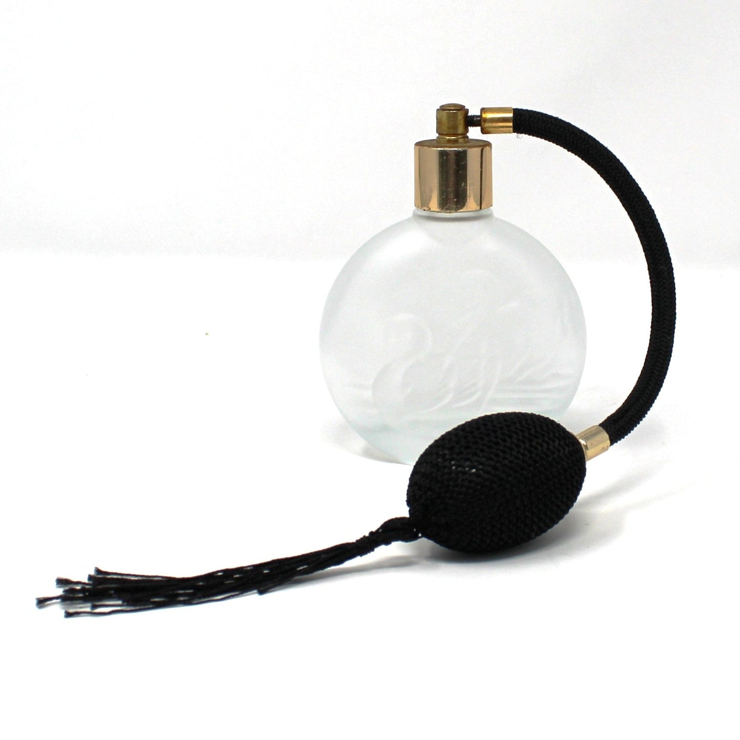 A vintage-style perfume atomizer spray bottle with a frosted glass body, a black rubber bulb, and a brass nozzle, set against a plain white background.