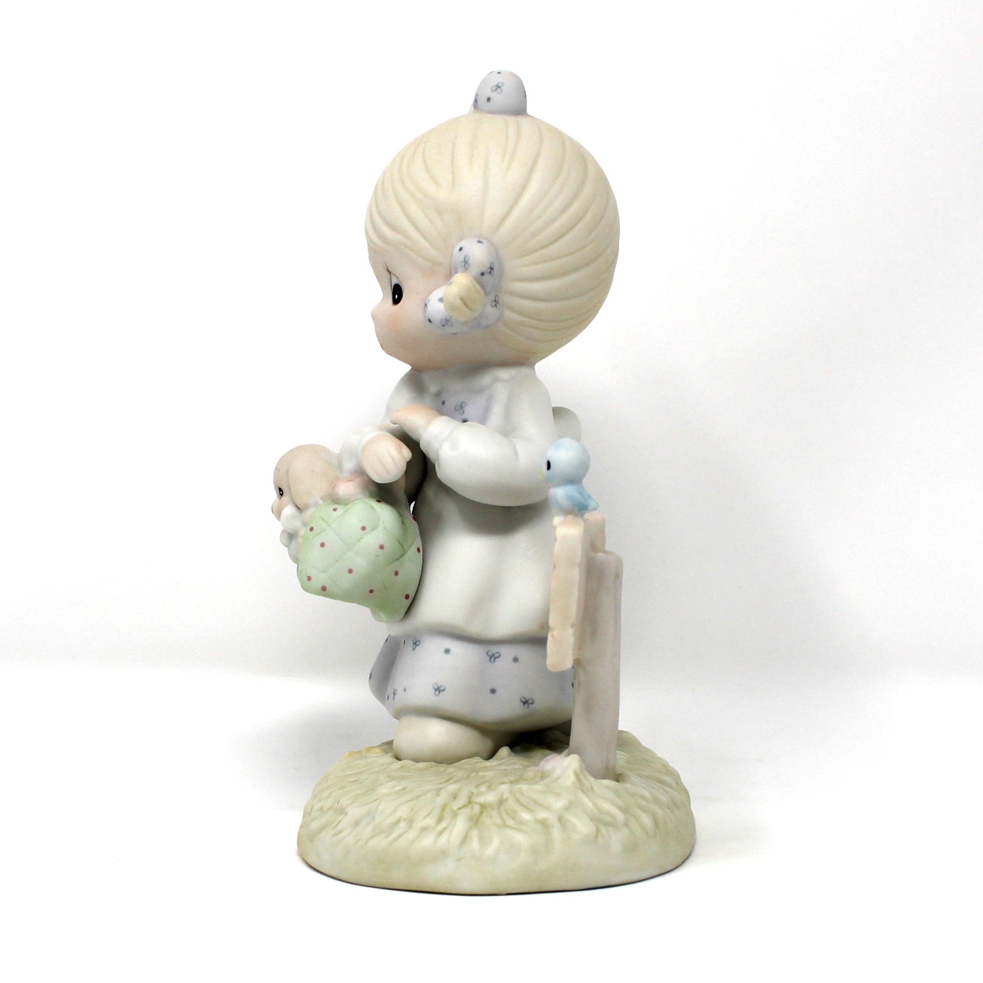 Side view of the vintage Precious Moments figurine from the Calendar Girls collection, titled July.  