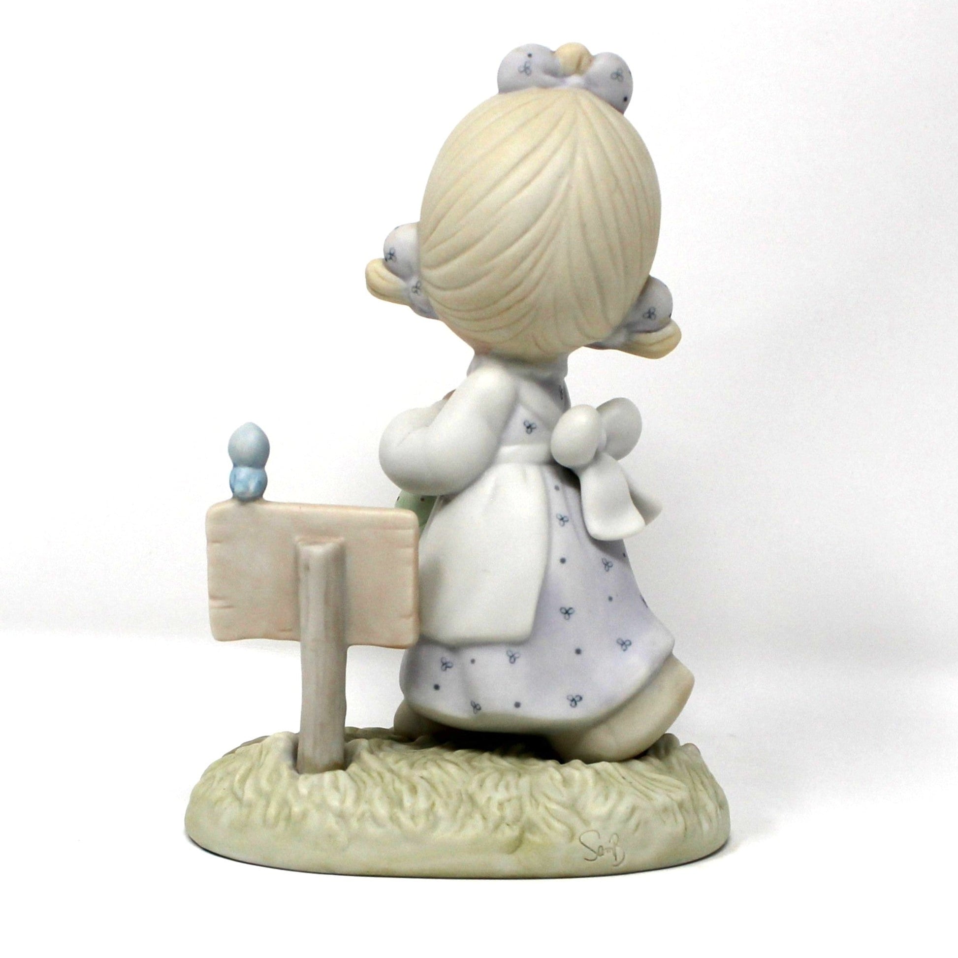 Back view of a vintage Precious Moments figurine from the Calendar Girls collection, titled July.  