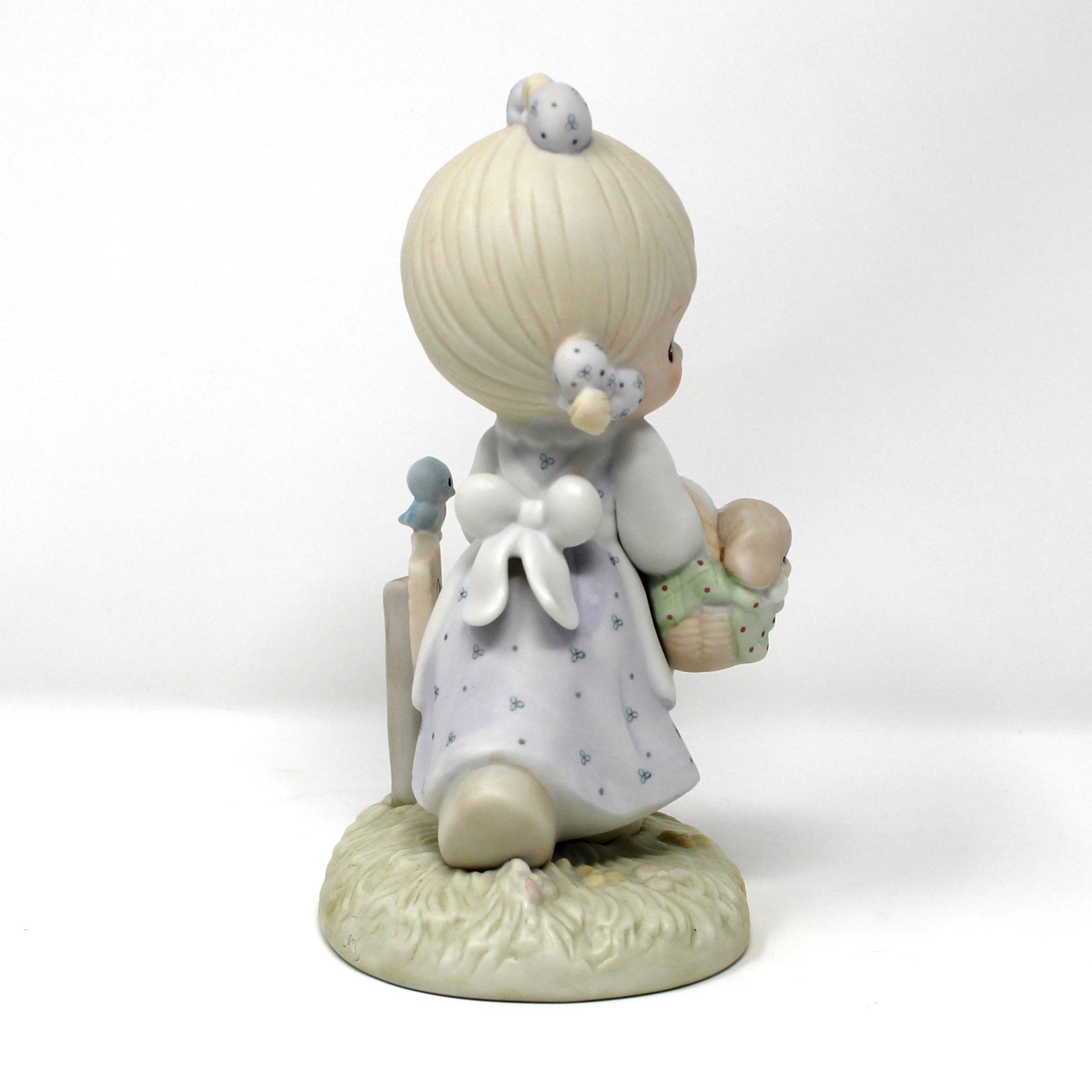 Side view of a vintage Precious Moments figurine from the Calendar Girls collection, titled July. 