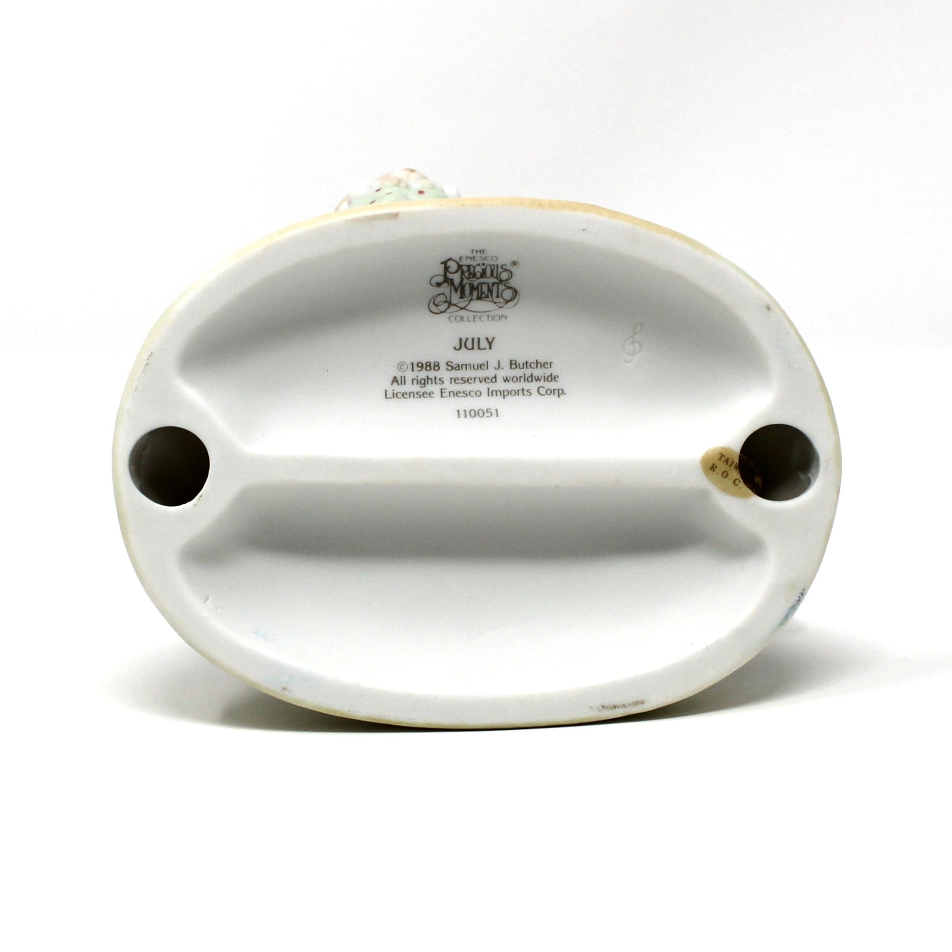 Bottom view of base from the vintage Precious Moments figurine from the Calendar Girls collection, titled July.  Dated 1992 (clef note).