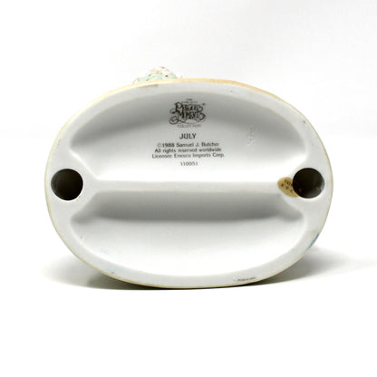 Bottom view of base from the vintage Precious Moments figurine from the Calendar Girls collection, titled July.  Dated 1992 (clef note).