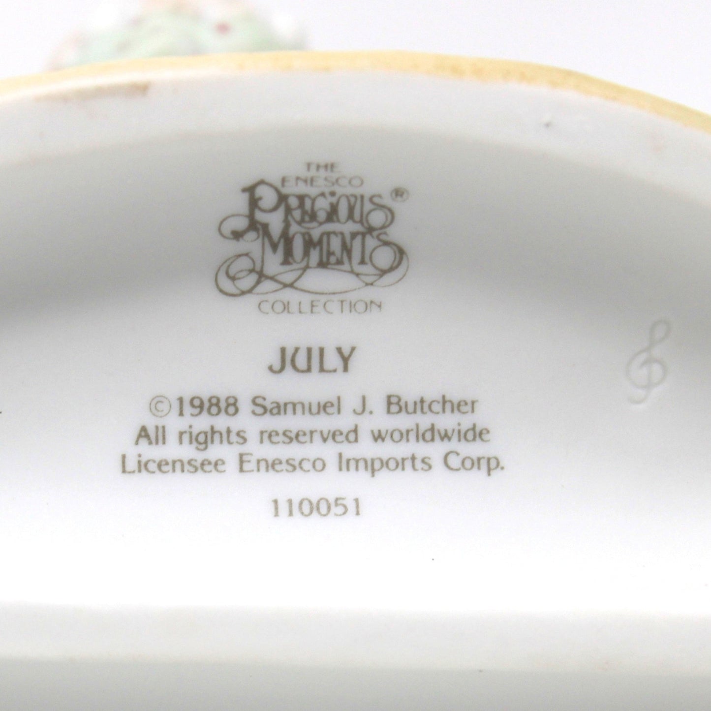 The underside of a ceramic July figurine from Precious Moments Calendar Girls Collection, July 1988
