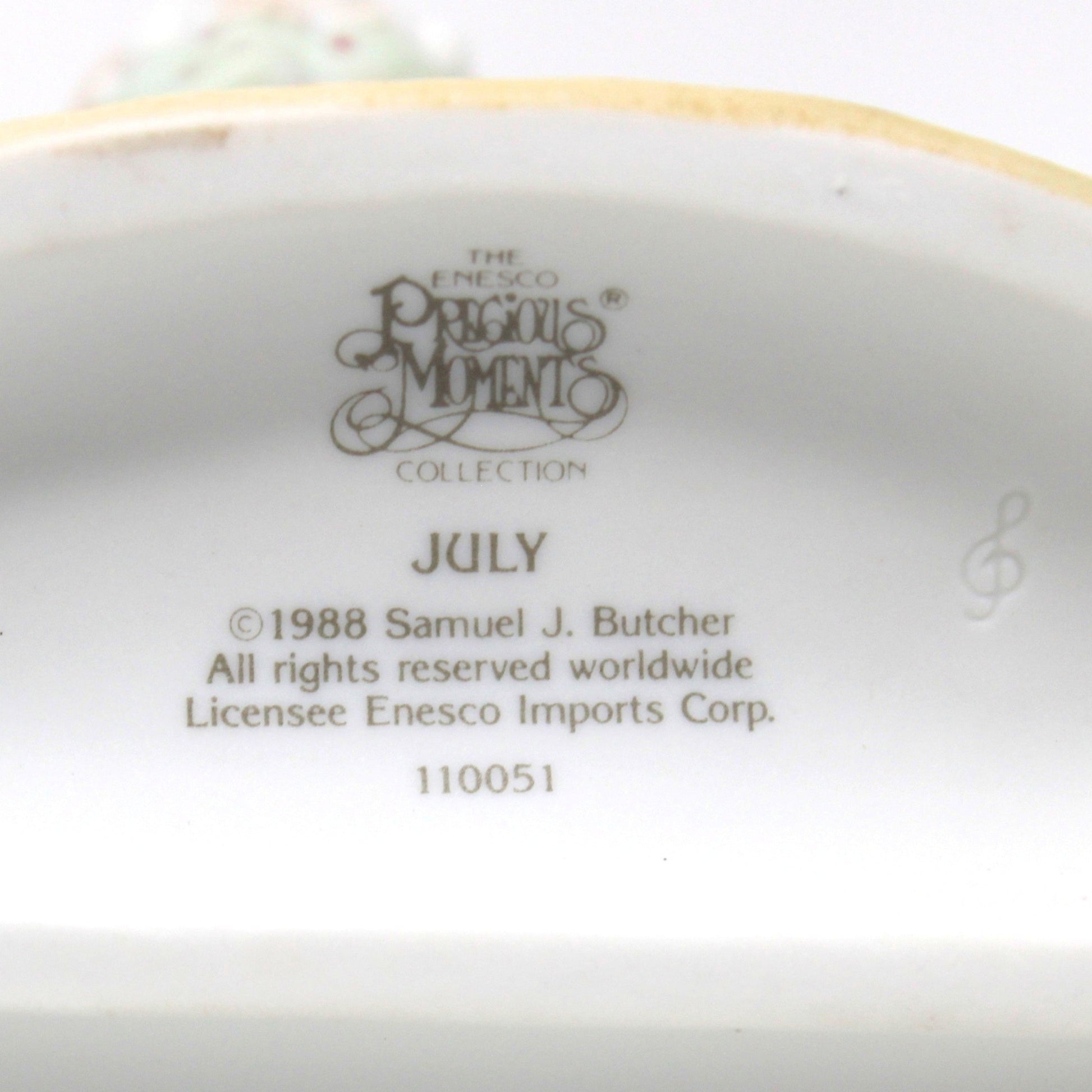 The underside of a ceramic July figurine from Precious Moments Calendar Girls Collection, July 1988