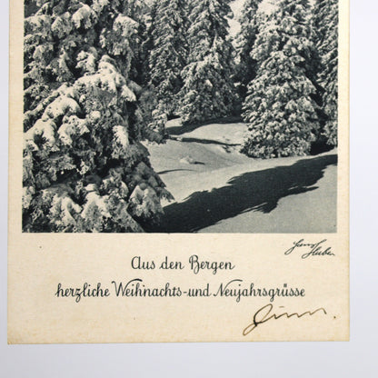 A vintage postcard featuring a black-and-white winter forest scene with snow-covered trees and a snowy path, Hans Huber 1930s