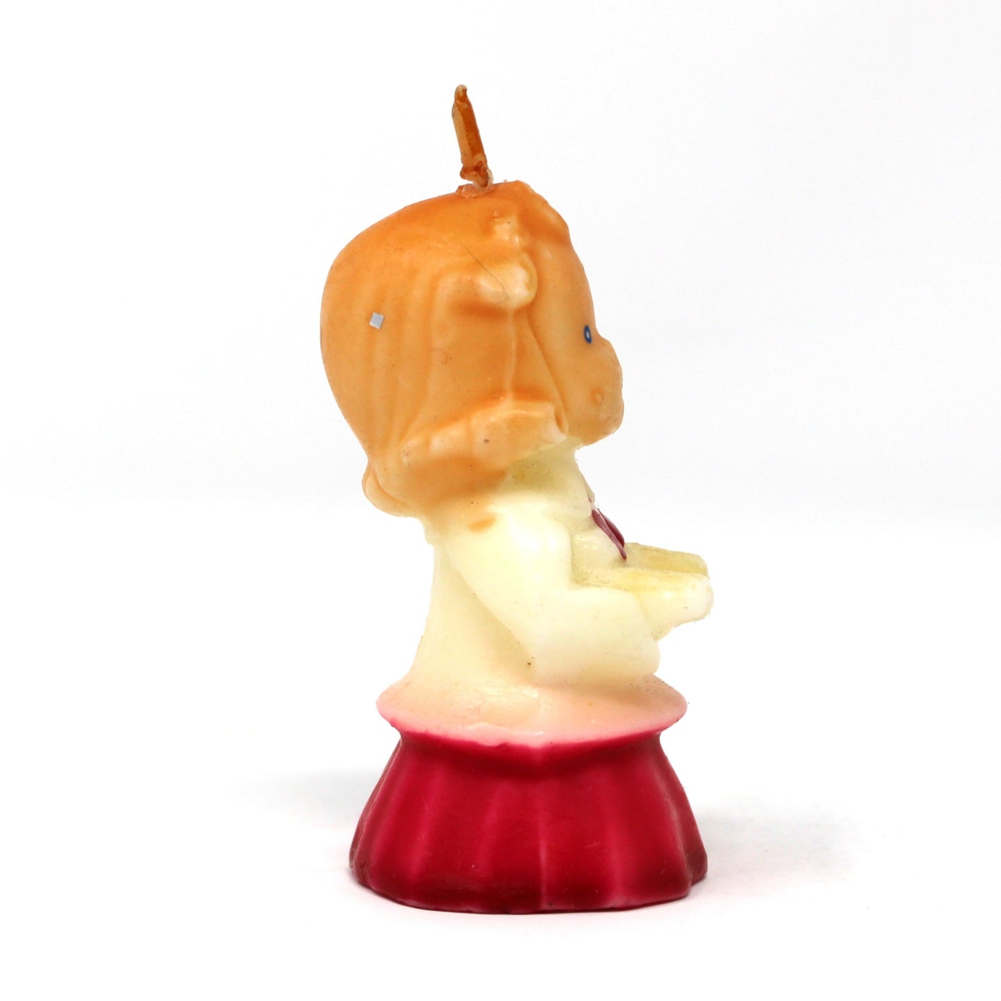 Side view of a vintage Gurley novelty candle shaped like a caroling girl with a white and red dress.