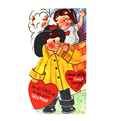 A vintage Valentine's Day greeting card. Die-Cut and movable, showing a fireman in a yellow coat hugging a red heart-shaped valentine with a smiling woman above