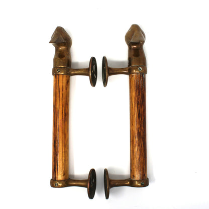 A pair of vintage-style wall door handles made of warm brown wood with bronze metal fittings and dark circular accents, shown against a plain white background.