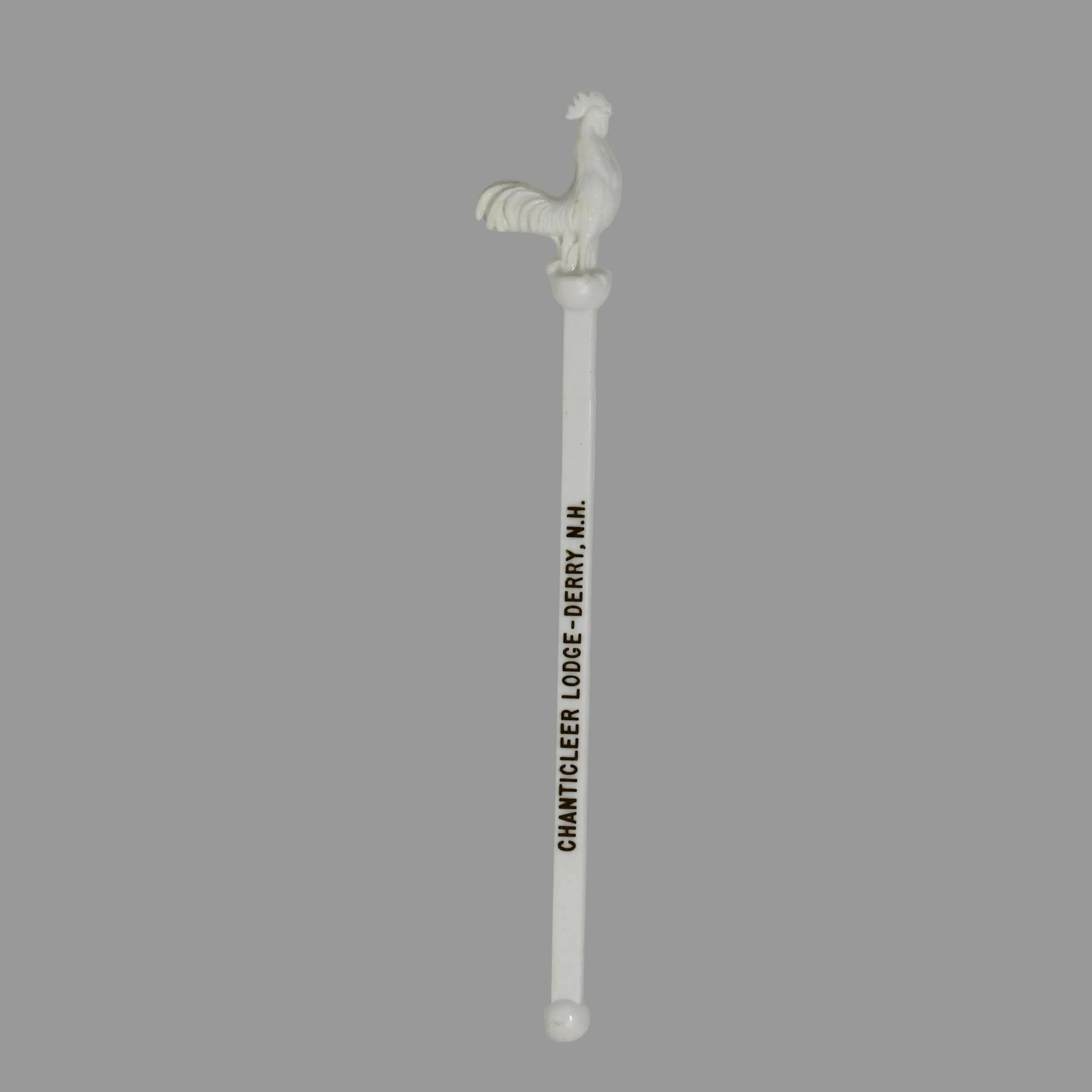 A vintage swizzle stick, cocktail stirrer with a rooster and goldprinted text reading 'CHANTICLEER LODGE'