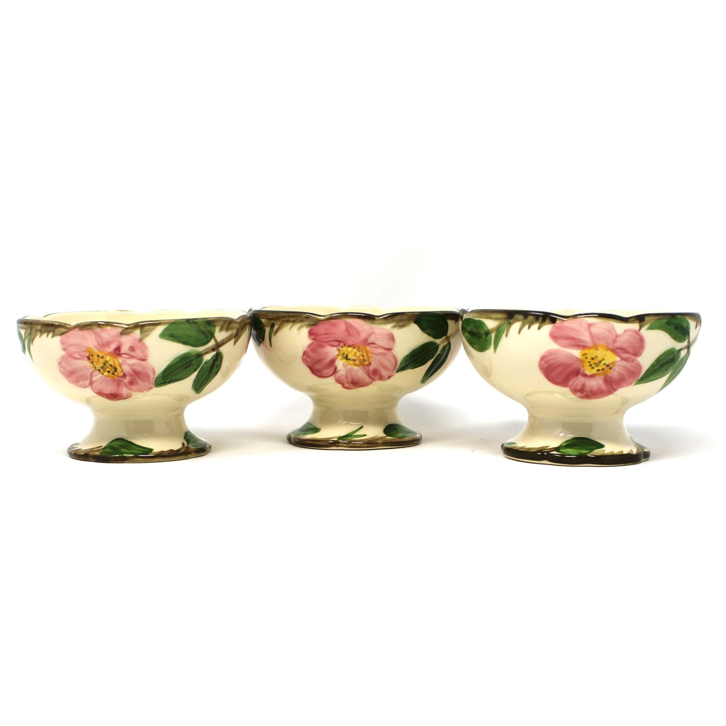 Three vintage Franciscan Desert Rose  footed bowls with a cream background and pink floral designs with green leaves.