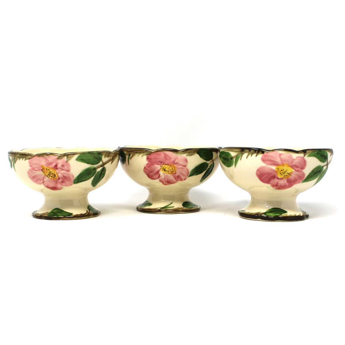 Three vintage Franciscan Desert Rose  footed bowls with a cream background and pink floral designs with green leaves.