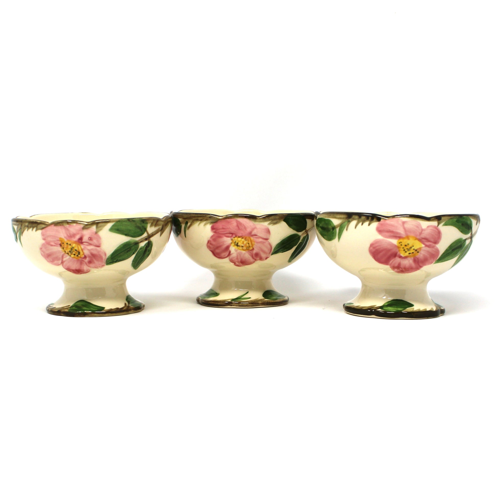 Three vintage Franciscan Desert Rose  footed bowls with a cream background and pink floral designs with green leaves.