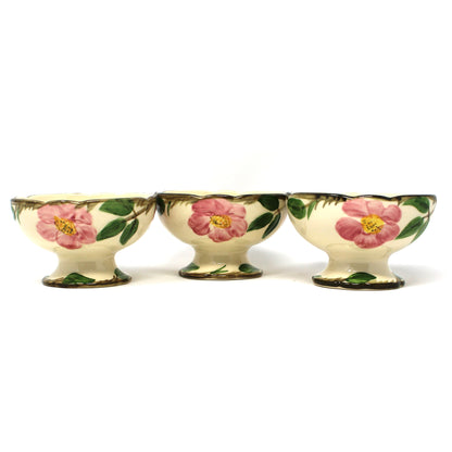 Three vintage Franciscan Desert Rose  footed bowls with a cream background and pink floral designs with green leaves.