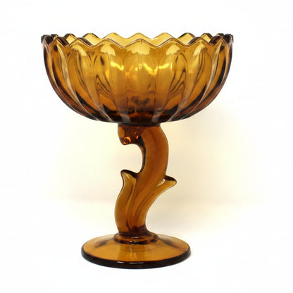 A vintage amber glass pedestal bowl from Indiana Glass.  Lotus Blossom compote with a scalloped rim and a sculptural stem.