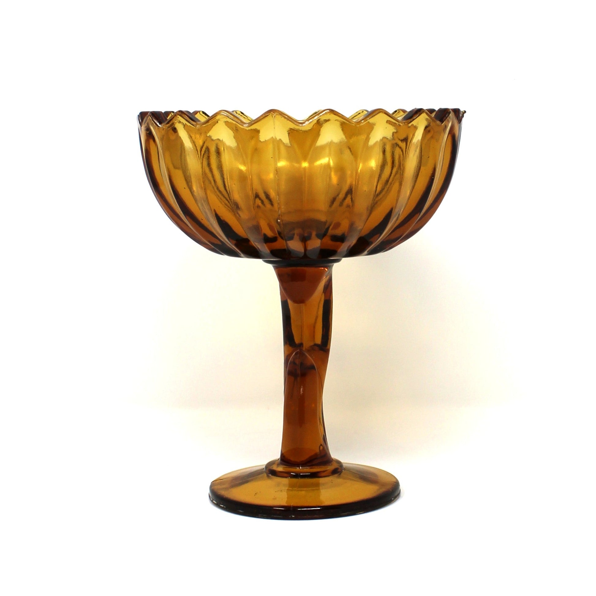 A vintage, amber-colored glass pedestal bowl with a scalloped rim, Indiana Glass, Lotus Blossom compote.