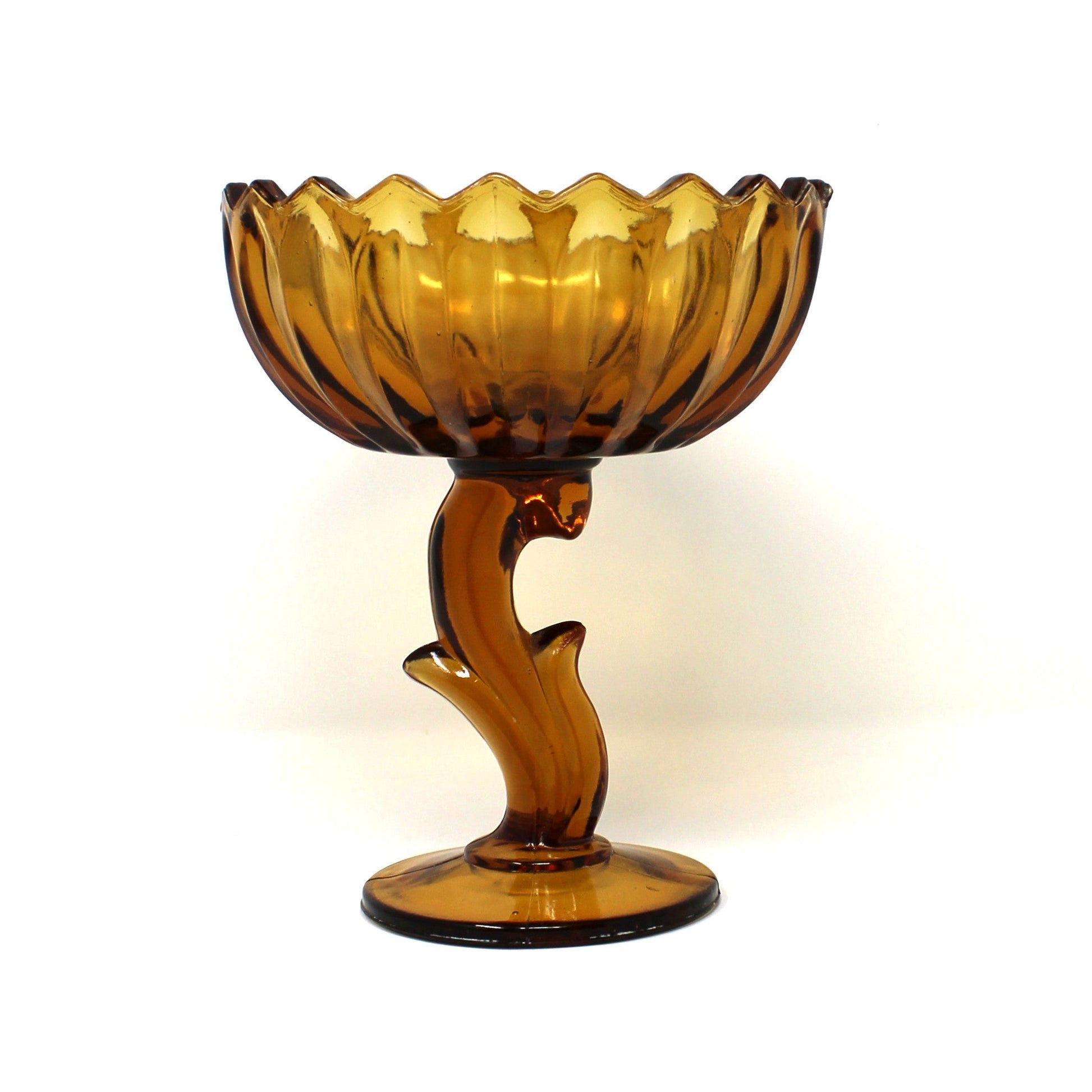 A vintage amber glass pedestal bowl from Indiana Glass.  Lotus Blossom compote with a scalloped rim and a sculptural stem.