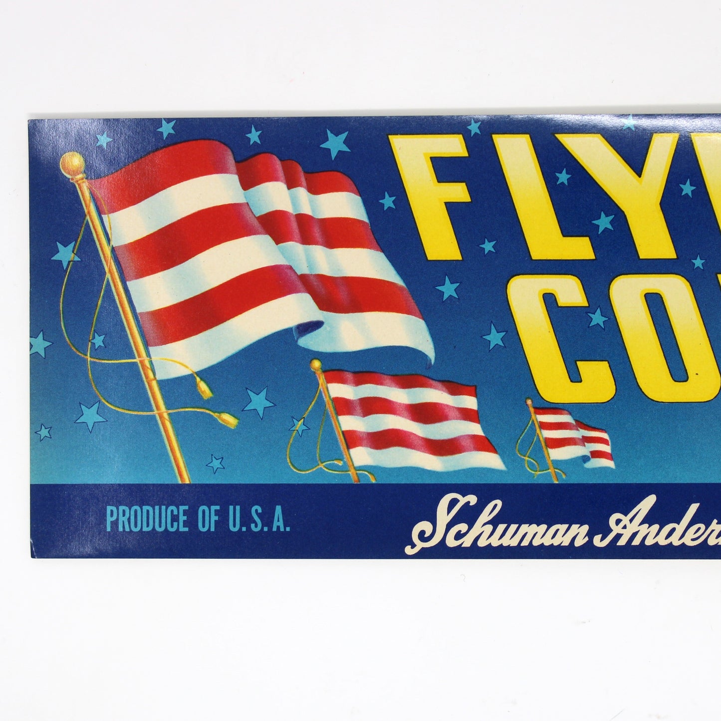 A vintage rectangular product box or label for 'Flying Colors Brand' by Schuman Anderholt Co., featuring a blue background with red and white American flags and large yellow lettering