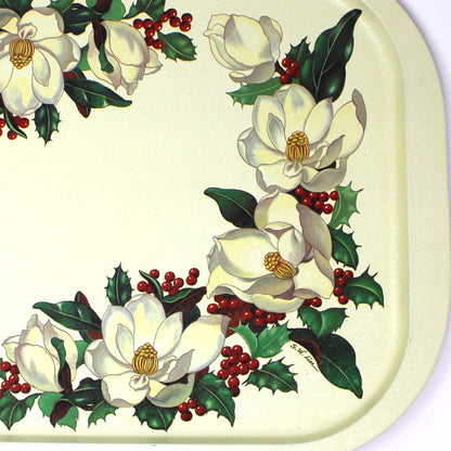 A vintage rectangular Christmas serving tray by Potpourri, with a cream-colored background, decorated with a border of white magnolia flowers, green holly leaves, and red berries.