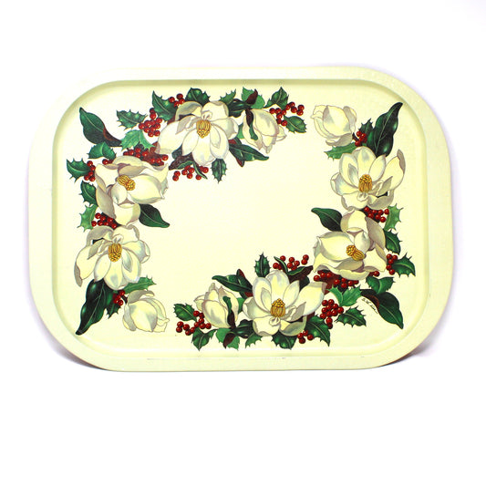 A vintage rectangular Christmas serving tray by Potpourri, with a cream-colored background, decorated with a border of white magnolia flowers, green holly leaves, and red berries.