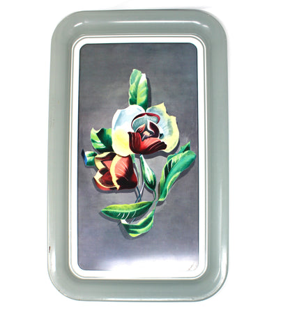 A rectangular vintage metal tray with rounded corners, featuring a painted floral design of white, red, and yellow flowers with green leaves on a dark gray background
