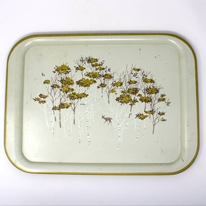 A vintage rectangular metal tray with rounded corners, featuring a gold-toned rim and a printed design of birch trees with golden foliage and a small deer on an off-white background.