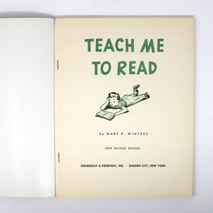 An open vintage book or binder showing the title page 'TEACH ME TO READ' in green text on an off-white page, photographed against a plain white background.
