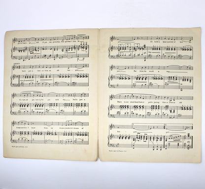 An open vintage sheet music with aged, yellowed pages displaying printed musical notation