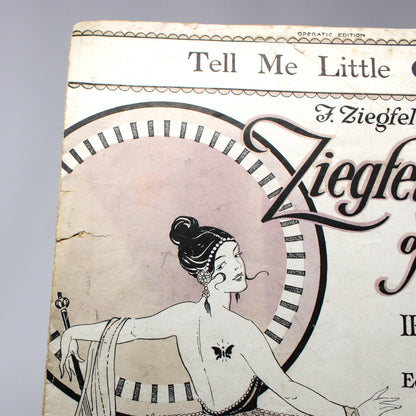 Vintage sheet music cover for 'Tell Me Little Gypsy' by Irving Berlin, featuring an Art Deco illustration of a woman, photographed against a white studio backdrop.