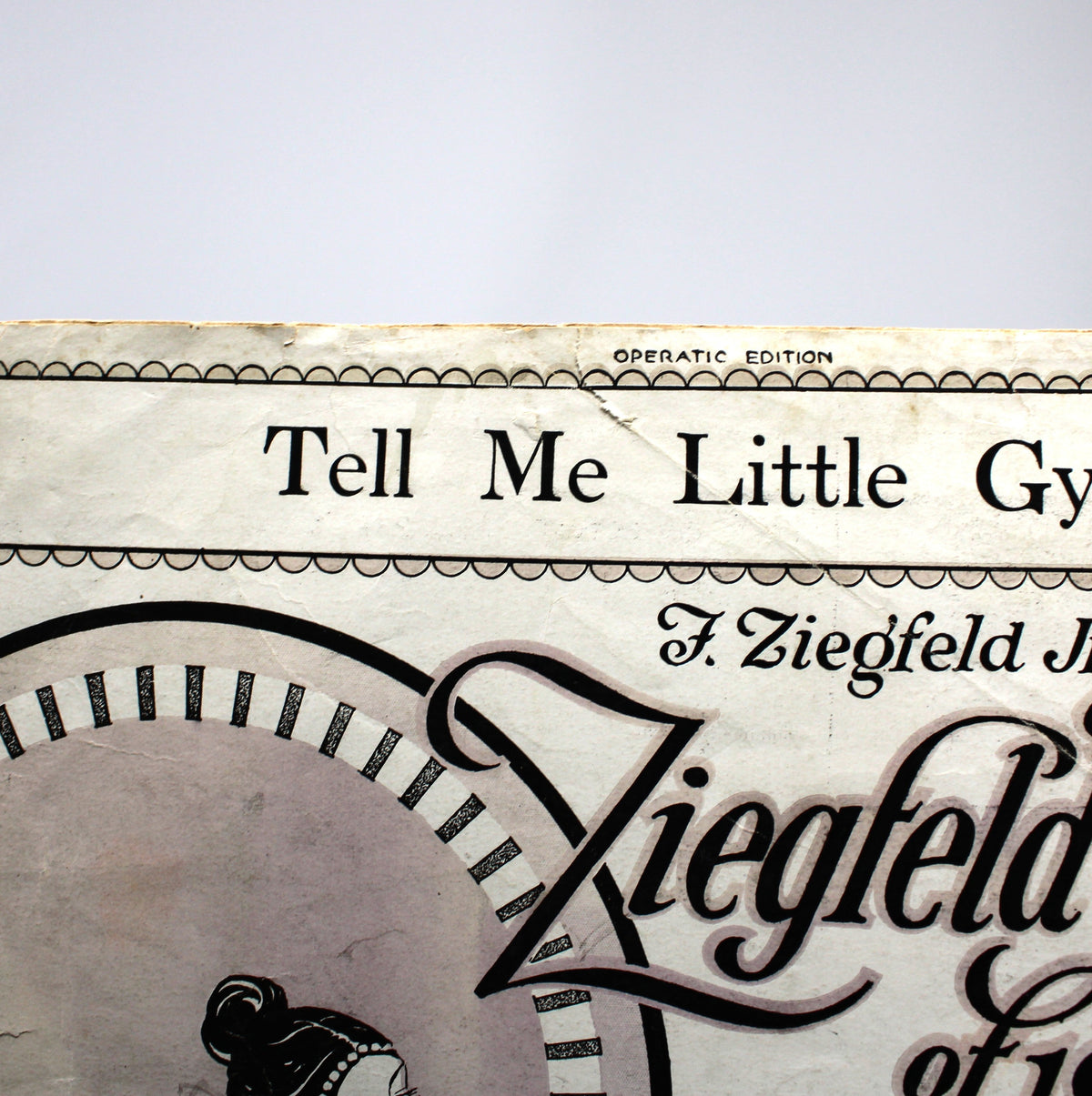 Vintage printed card or booklet cover reading 'Tell Me Little Gypsy' and 'Ziegfeld follies et 1929' with ornate black typography on aged cream paper, photographed against a light gray background.